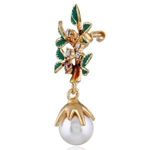 Détail d'une broche branche dorée avec feuilles en émail vert et perles blanches