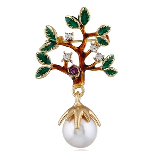 Détail de broche arbre avec feuilles en émail vert, cristaux et grande perle