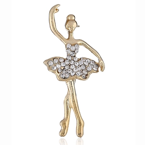 Macro detail of elegant golden ballet dancer brooch with white rhinestones on skirt