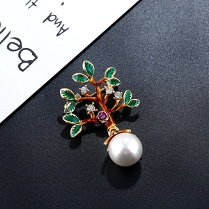 Détail de la broche arbre avec feuilles en émail vert, placage or et pendentif perle