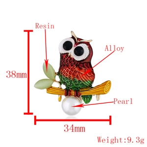 Creative owl brooch in red and green enamel with white pearl drop and resin leaf detail