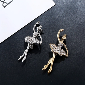 Detailed macro view of gold and silver ballet dancer brooches with sparkling crystals