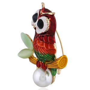 Side view of owl brooch featuring colorful enamel, white pearl, and back pin detail