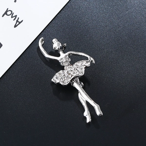 Detail of a sparkling silver ballerina brooch with clear rhinestones on a textured background