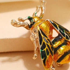 Charming golden cicada insect brooch with colorful enamel wings and green crystal accent