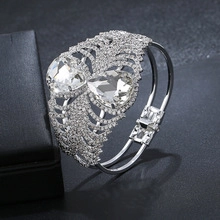 Detailopname van de verzilverde open armband met druppelvormige kristallen en pavé strass