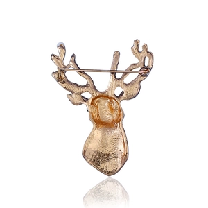 Vue arrière d'une broche cerf de Noël dorée avec un fermoir de sécurité sur fond blanc