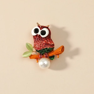 Chic owl brooch with enamel feathers, cat eye leaves, and a large white pearl drop