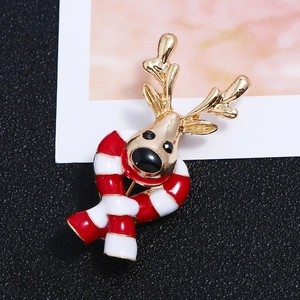 Christmas reindeer brooch in gold metal with red striped scarf on black background