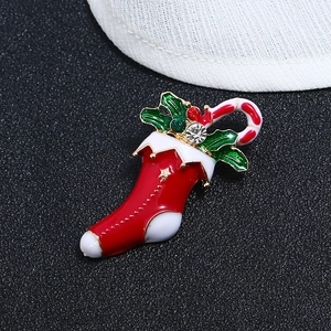 Colorful Christmas brooch featuring a red sock, candy cane, and holly with crystals