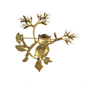 Back view of owl on branch brooch with antique gold metal and faux pearl inlay