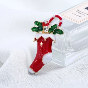 Detailed close-up of a Christmas stocking brooch with enamel finish and sparkling rhinestones