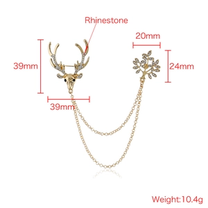 Vintage gold reindeer brooch with rhinestones and double chains on white background