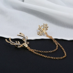 Detailed macro view of vintage rhinestone elk head and tree chain brooch in gold plating
