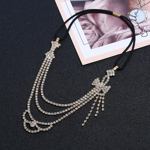 Gros plan d'un bandeau à strass avec nœud et détails de franges sur fond noir mat