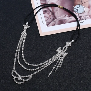Détail des glands en strass et du nœud élégant sur le bandeau élastique noir