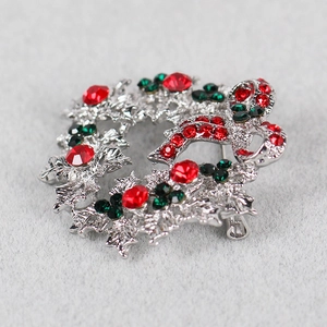 Macro view of Christmas wreath brooch with sparkling red and green rhinestones and bow