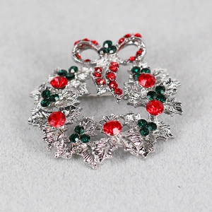 Detailed view of festive Christmas wreath brooch with sparkling red and green rhinestones