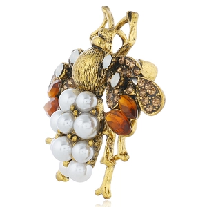 Detailed macro view of vintage gold bee brooch with pearls and amber crystals