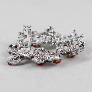 Rear view of silver wreath brooch with red rhinestones and pin closure on fur texture