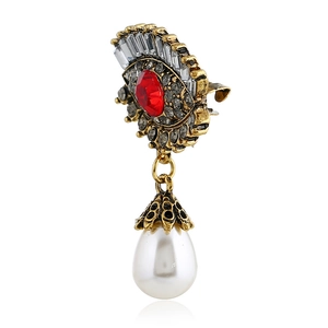 Macro detail of retro evil eye brooch with red crystal, diamonds and pearl drop