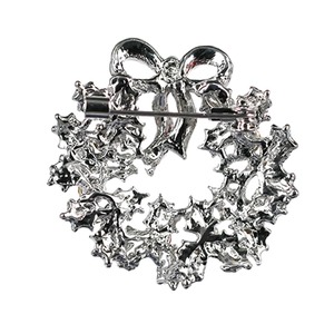 Silver-toned Christmas wreath brooch back view with bow accent and safety pin closure