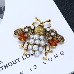 Detail of vintage bee brooch with amber gemstones, brown crystals and white faux pearls