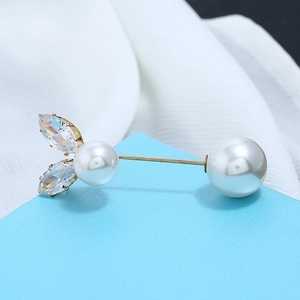 Detailed macro shot of a pearl brooch with sparkling crystals and a golden pin finish