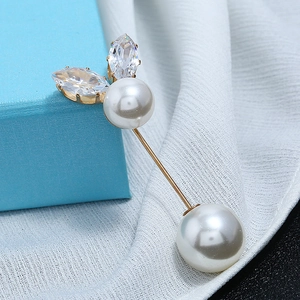Detail shot of a gold-plated pearl brooch pin with marquise-cut crystals and white pearls