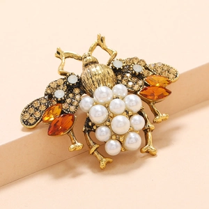 Vintage gold beetle brooch featuring white pearls and orange marquise rhinestones