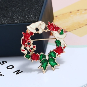 Gros plan d'une broche couronne de Noël festive en émail sur un coffret cadeau bleu