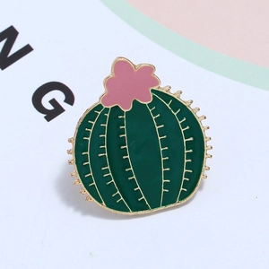 Detail of a green cactus enamel pin with a pink flower and golden metallic edges