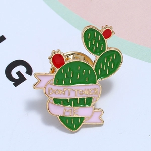 Detailed view of enamel cactus brooch with 'DON'T TOUCH ME' slogan and gold accents