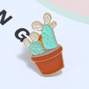 Detail of creative cartoon cactus enamel pin with gold plating and green plant texture