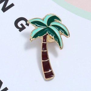 Detail of a tropical palm tree brooch with golden frame and green enamel finish