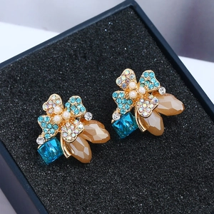 Elegant gold flower earrings with blue crystals and pearls in jewelry box