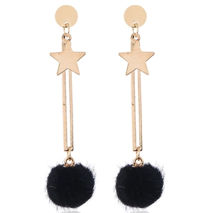 Detailed view of gold star earrings with black faux fur balls and long metal bar drops
