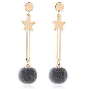 Close-up of dangling star moon earrings with dark grey faux fur pom-poms on white background