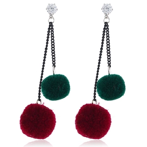 Detail of cherry-style drop earrings with plush pom-poms and black metallic chains