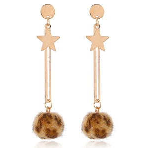 Detail of star pendant and leopard print fur ball on long gold earrings with white background