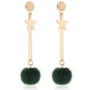 Close-up of golden star drop earrings with decorative dark green faux fur pom poms