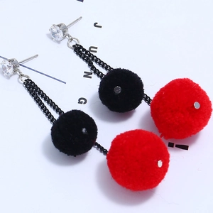 Detail of furry pompom earrings with sparkling zircon studs and long chain pendants