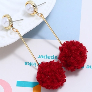 Detail of red faux fur pompom earrings with gold bars and white imitation pearls