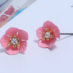 Nahaufnahme der rosa Blütenohrringe mit klarem Kristall und goldener Perlenverzierung