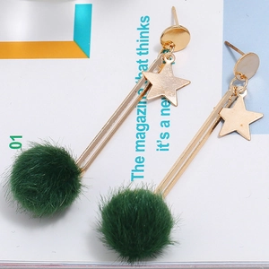 Detail view of gold star dangle earrings with deep green mink fur pompom charms