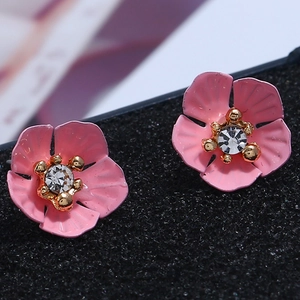 Nahaufnahme der rosa Blumenohrstecker mit Kristallmitte und goldenem Staubblatt-Detail