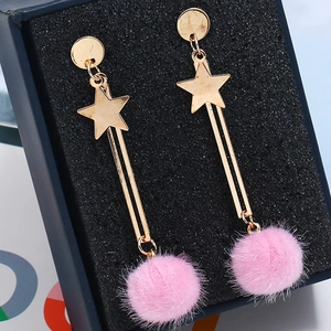 Detail of gold star earrings featuring long dangling chains and pink faux fur pom poms