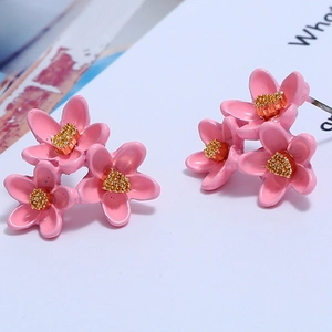Detail von rosa Blumenohrringen mit drei kleinen Blüten und goldenen Akzenten