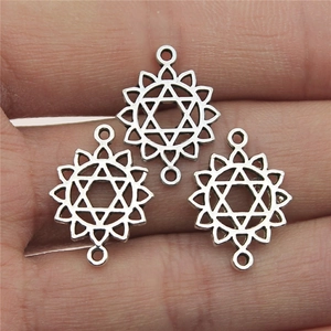 Three antique silver chakra lotus connectors for DIY jewelry making, held in hand for scale