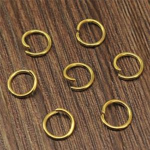Set goldene Biegeringe für DIY-Schmuckherstellung auf natürlichem Holzhintergrund